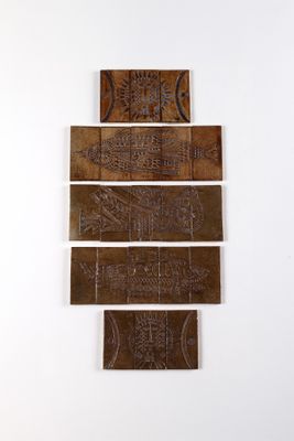four pieces of wood with carvings on them on a white wall