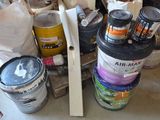 several cans of paint are stacked on a pallet in a room