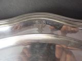 a silver plate with a design on it on a table