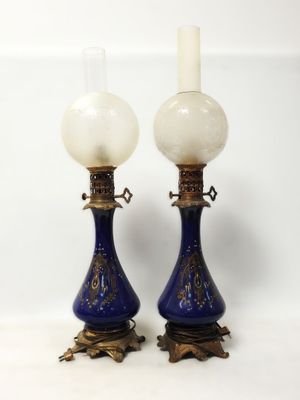 une paire de vases bleus et blancs rehaussés de touches dorées sur fond blanc