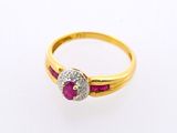 a close up of a gold ring with a ruby stone