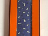 an orange box with a blue tie in it on a white surface