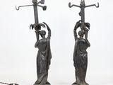 pair of antique bronze figurines of a woman holding a lamp