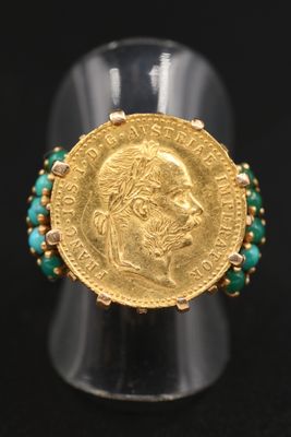 Gros plan sur une bague ornée d'une pièce d'or