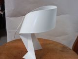 a white table lamp that is on a wooden table