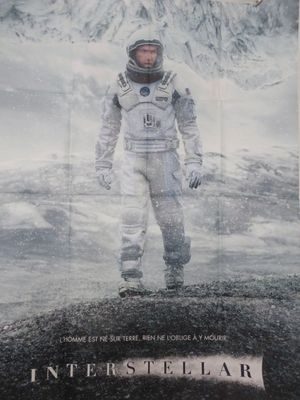 affiche représentant un homme en combinaison spatiale debout devant une montagne