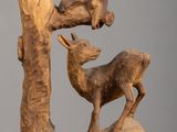 une sculpture en bois représentant un cerf et un oiseau dans un arbre