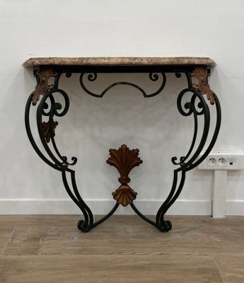 une console ciselée avec un plateau en marbre posée sur un parquet