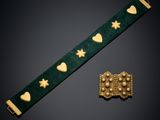 a close up of a bracelet and a broocher on a table