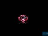 a close up of a pink diamond on a black surface