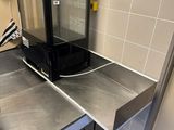 plan de travail en acier inoxydable dans une cuisine professionnelle équipée d'une porte vitrée