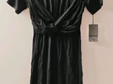 black leather dress hanging on a hanger on a wall