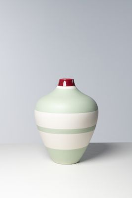 un vase vert et blanc posé sur une table blanche