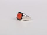 a close up of a ring with a red stone on it