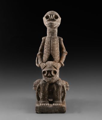 une image représentant une statue d'un squelette assis sur une tête humaine