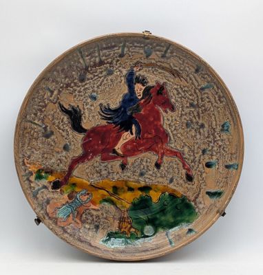 a plate with a painting of a woman riding a horse