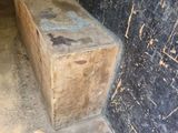 a wooden bench in the middle of a dirty room