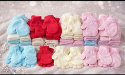 de nombreuses paires de mitaines pour bébé posées sur une couverture