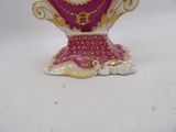 a pink and gold vase on a white table