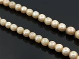 un gros plan sur un collier de perles sur une surface noire