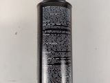 a close up of a bottle of black liquid on a white surface