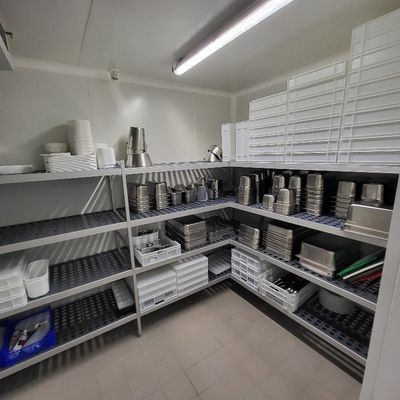 une pièce avec de nombreuses étagères sur lesquelles sont posés des casseroles et des poêles
