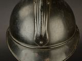 a silver helmet on a metal stand on a black background
