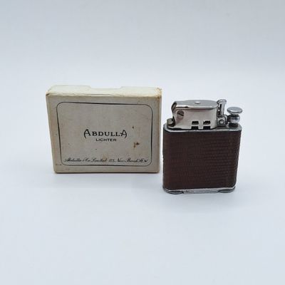 un petit briquet posé devant une boîte