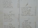 an old manuscript with writing on it and a picture of a clock on the wall