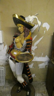 a statue of a woman holding a tray in a room