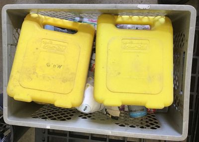 two yellow containers sitting in a box on top of a shelf