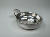 un bol en argent avec une cuillère sur une table