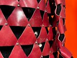 a close up of a red and black costume with black and white diamonds
