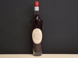 an old bottle of wine sitting on top of a wooden table