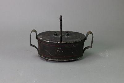 a small metal pot with a handle on a table