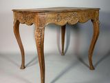 une image représentant une table en bois avec un plateau et des pieds sculptés