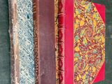 trois vieux livres sont empilés sur une table