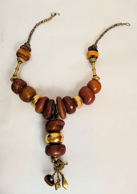 a close up of a necklace on a white surface
