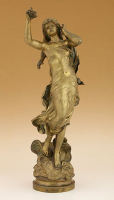 une statue antique en bronze représentant une femme tenant un oiseau dans la main