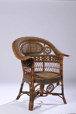 une chaise en osier posée sur une surface blanche
