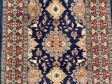 a blue and red rug with a medallion design on it
