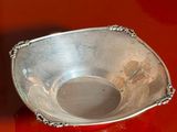 a silver bowl sitting on a red surface