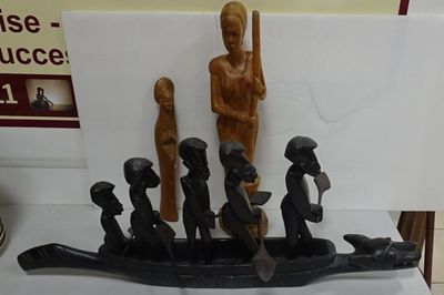 carvings of people in a boat on a table in a room