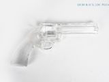 un gros plan d'un revolver posé sur une surface blanche, avec un fond blanc