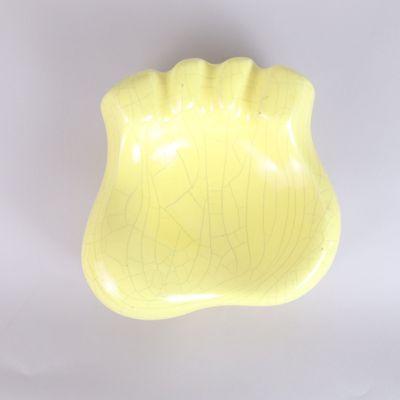 a yellow bowl that is sitting on a white surface