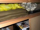 a shelf with a lot of clothes and a bag