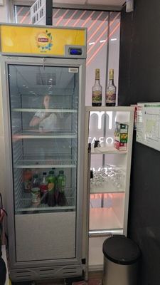 un réfrigérateur qui se trouve dans le coin d'une pièce