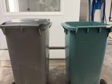 two trash cans sitting next to each other on the floor