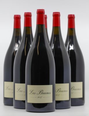 six bouteilles de vin rouge sont alignées sur une surface blanche