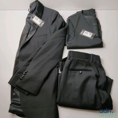 deux pièces d'un costume noir et un pantalon posés sur une surface blanche